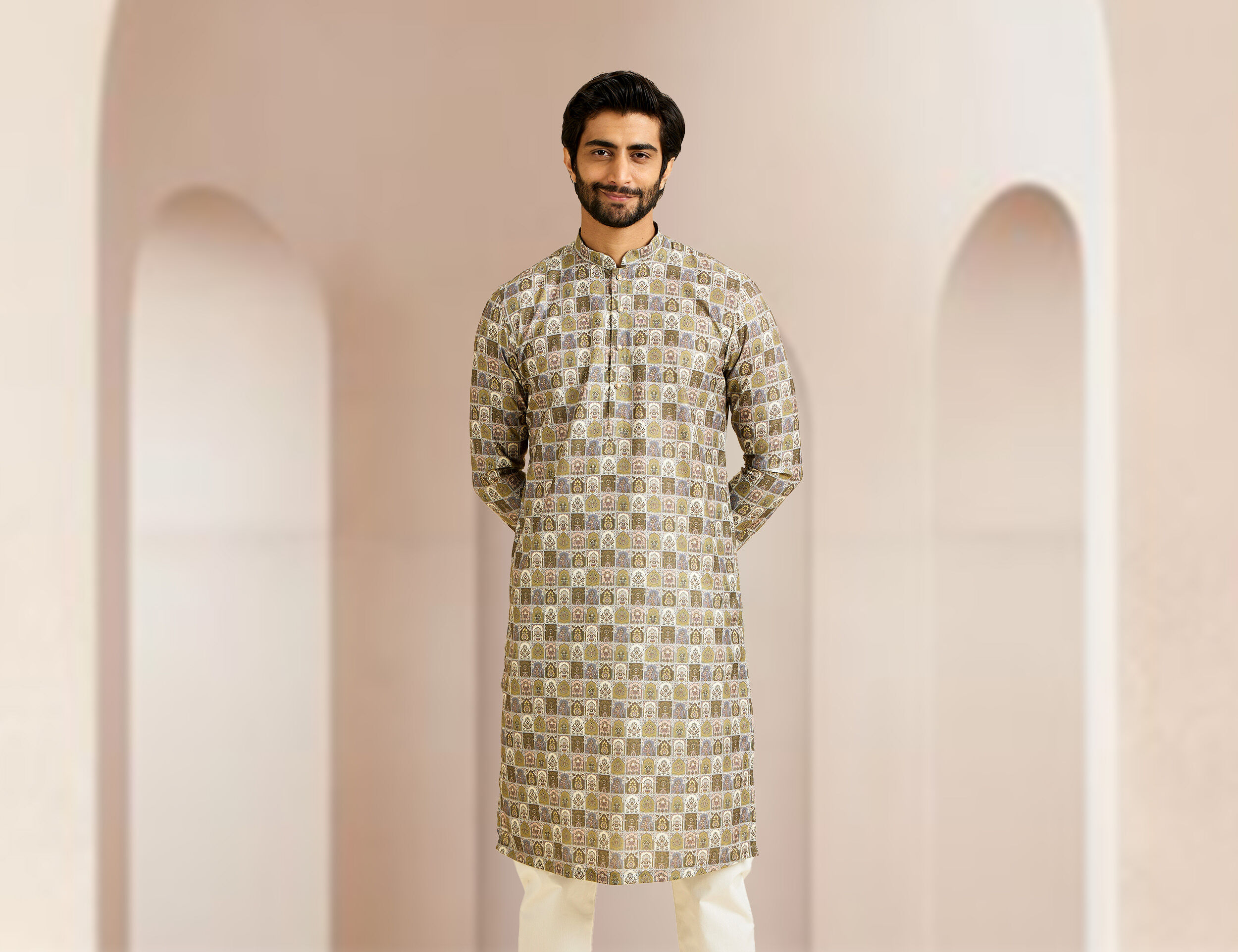 Man in an elegant printed brown kurta styled with white pajama, a sophisticated wedding outfit choice.